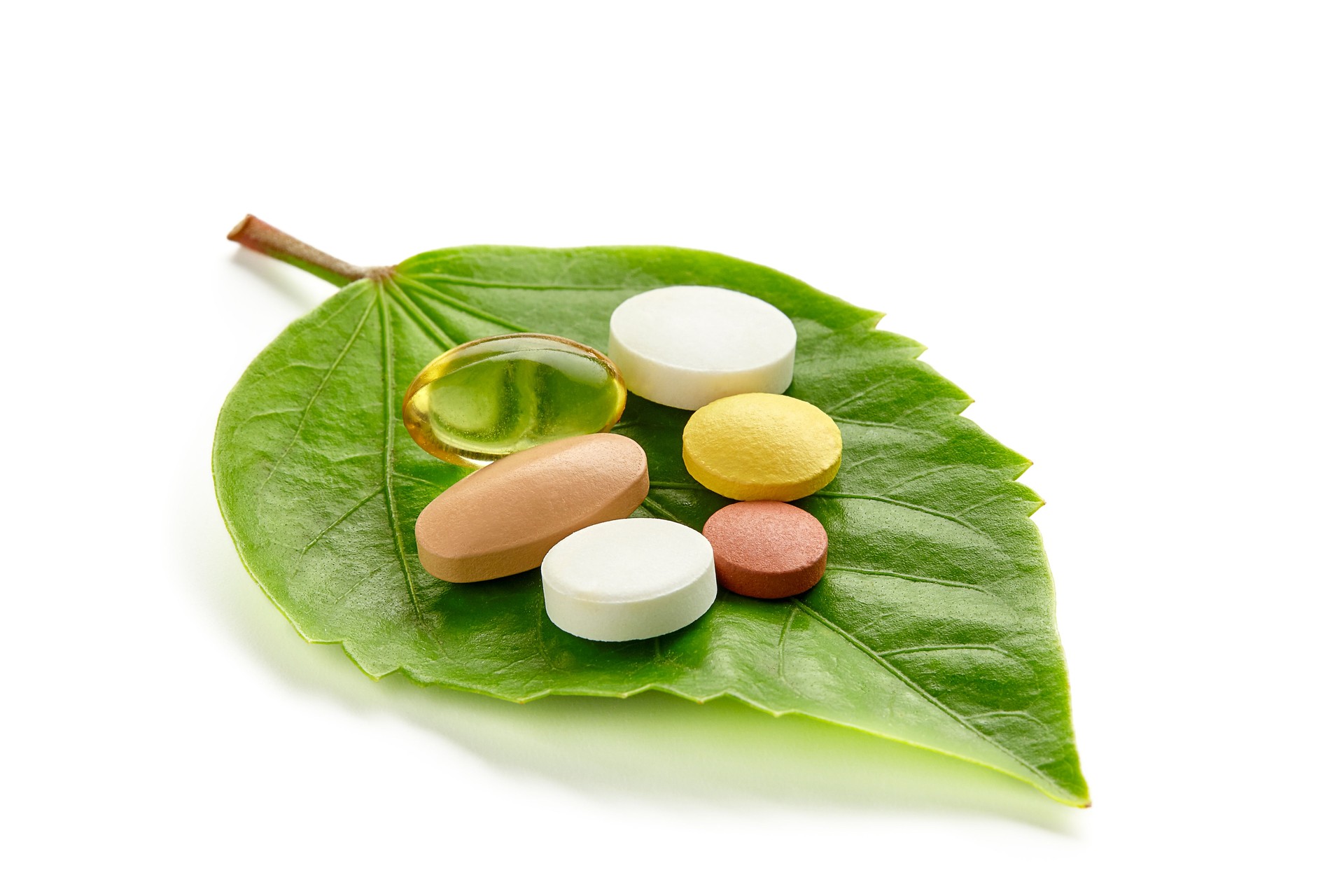 Vitamins and Pills on a Green Leaf