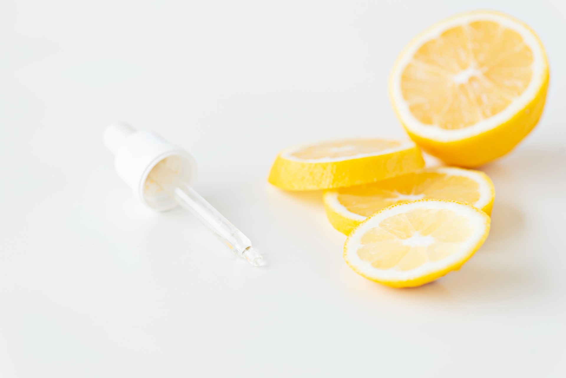 Lemon Slices with Dropper on White Background