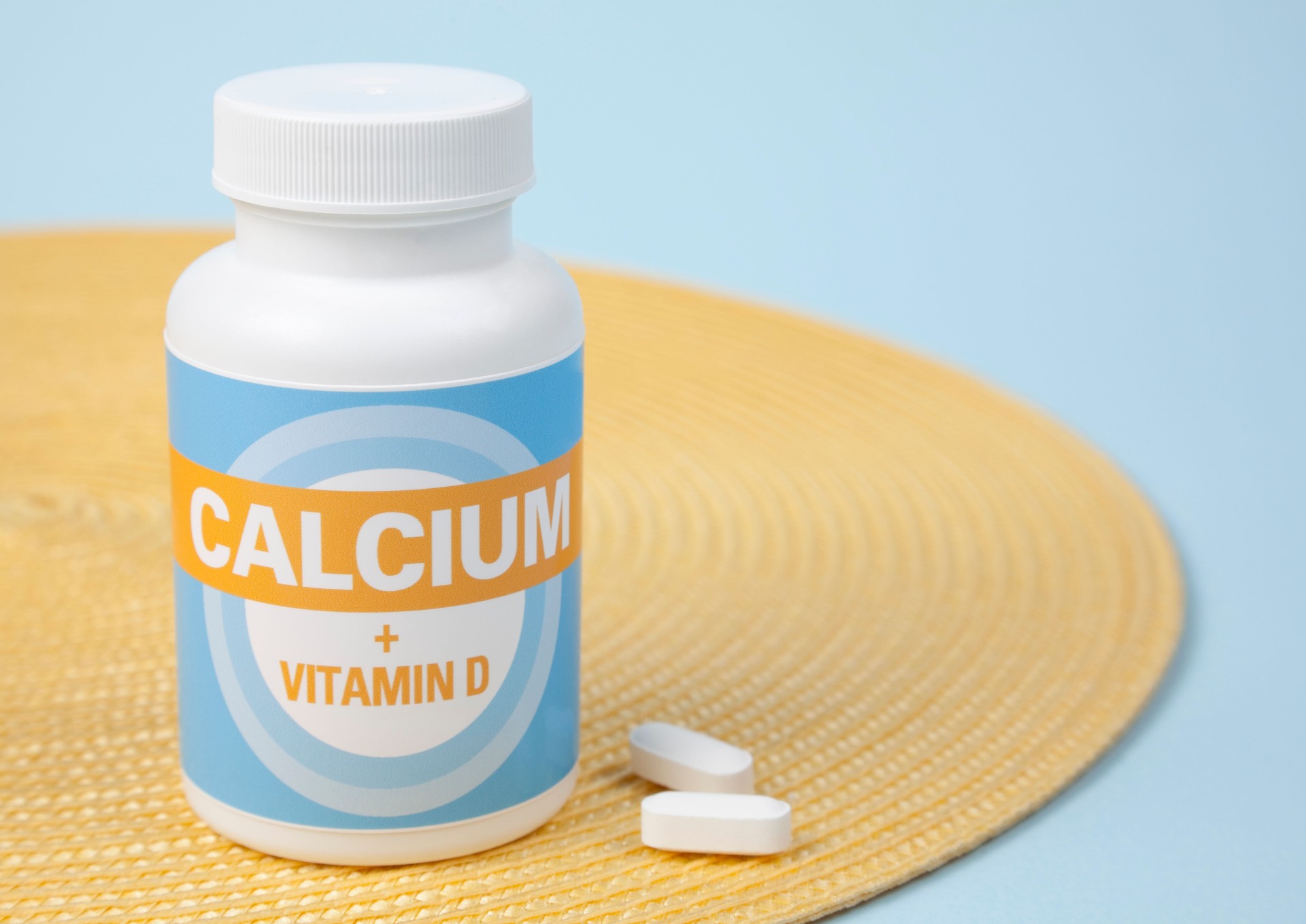 Bottle of calcium tablets on a yellow placemat on table